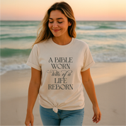 Christian t-shirt with the phrase “A Bible Worn Tells of a Life Reborn”; unisex cotton tee celebrating transformation through God's Word.
