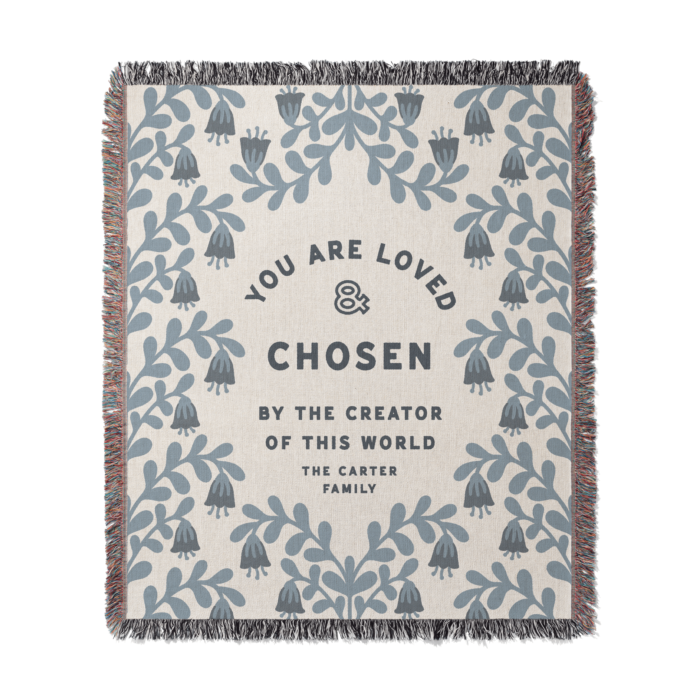 Blanket with floral pattern and text 'You are loved & chosen by the creator of this world. The Carter Family' on a white background.