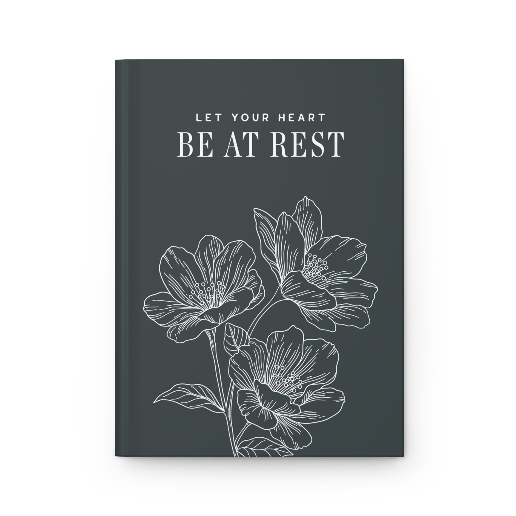 Book with floral design and text 'Let your heart be at rest' on a dark background