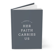 Gray book with 'Her Faith Carries Us' text on a white background