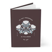 Brown notebook with floral design and text on a white background