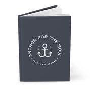 Dark blue notebook with white anchor design and text on a white background