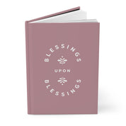 Pink notebook with 'Blessings Upon Blessings' text on a white background