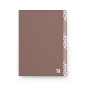 Brown notebook with white patterned edge on a white background