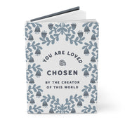 Book with motivational quote 'You are loved & chosen by the creator of this world' on a white background