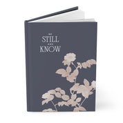 Book with floral design and 'Be Still and Know' text on a white background