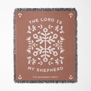 Brown blanket with white floral design and text on a white background