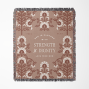 Decorative throw blanket with floral pattern and text on a beige background