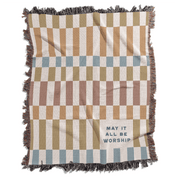 Checkered throw blanket with text 'May it all be worship' on a white background