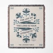 Woven blanket with decorative text and floral patterns on a white background