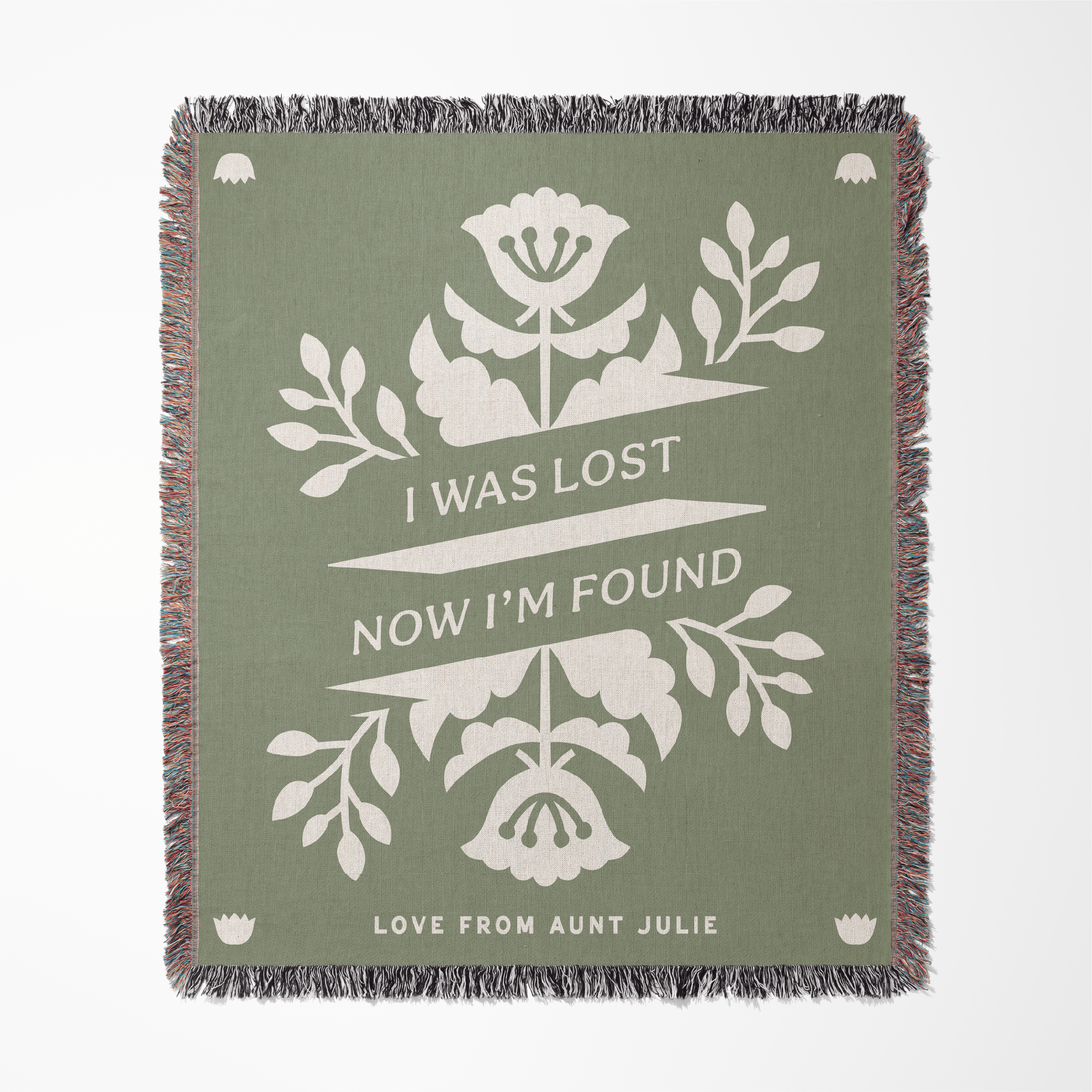 Green blanket with white floral design and text on a white background