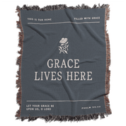 Gray blanket with text and a flower design, featuring motivational phrases.