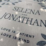 Text on a fabric with 'Selena and Jonathan' and 'Love is Patient, Love is Kind' printed on it.