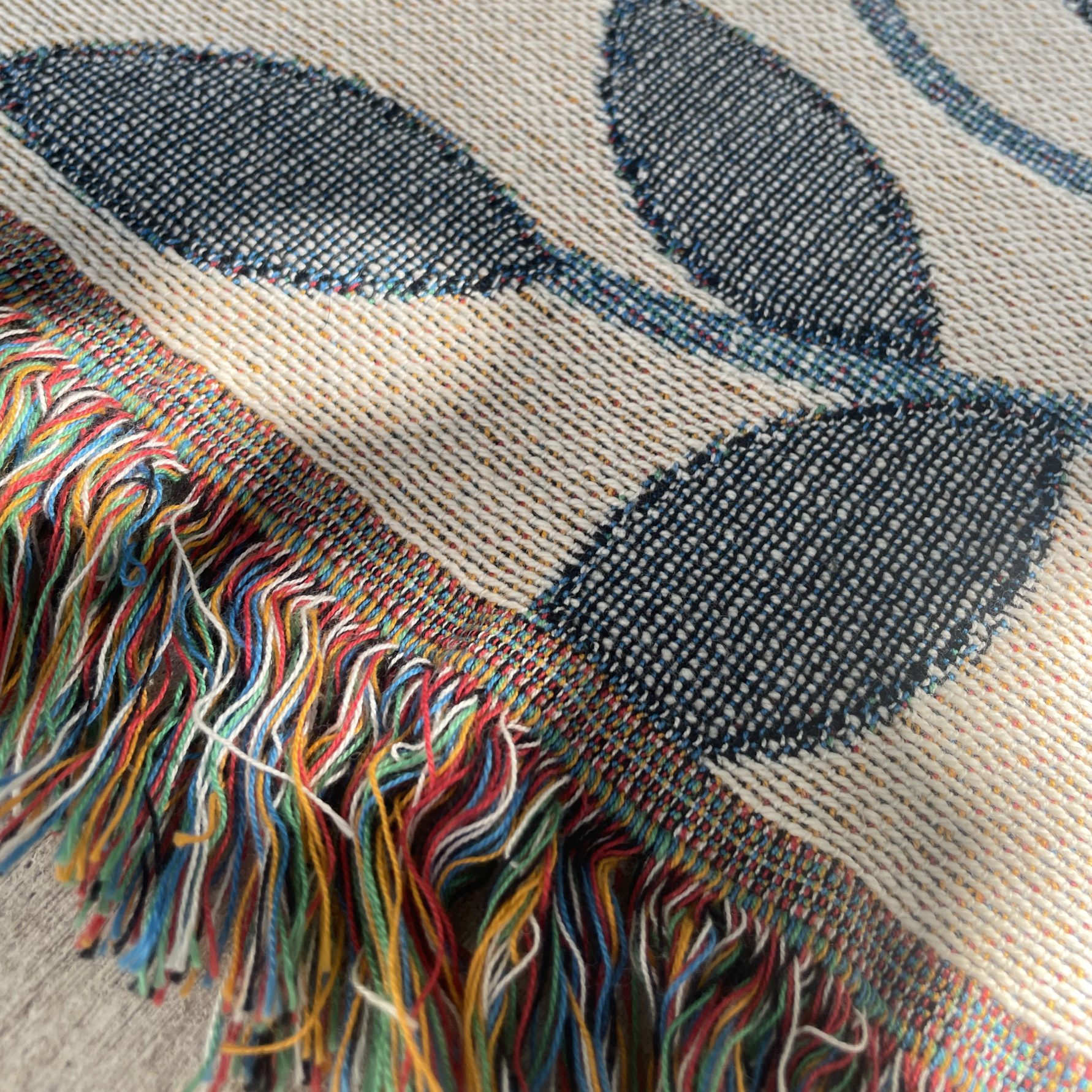 Textile with leaf pattern and colorful fringe