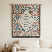 Decorative wall hanging with floral pattern and text above a sofa