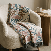Floral-patterned throw blanket draped over a cozy armchair with a side table in the background.