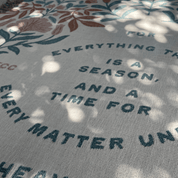 Text on fabric with floral patterns, featuring a quote.