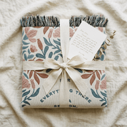 Gift wrapped in floral paper with a bow on a textured surface