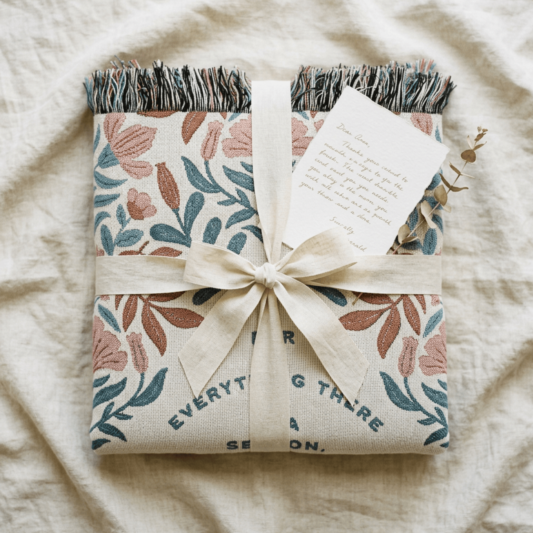 Gift wrapped in floral paper with a bow on a textured surface