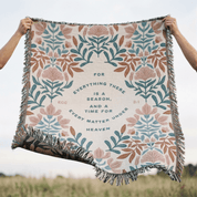 Floral patterned blanket with text held up against a field background