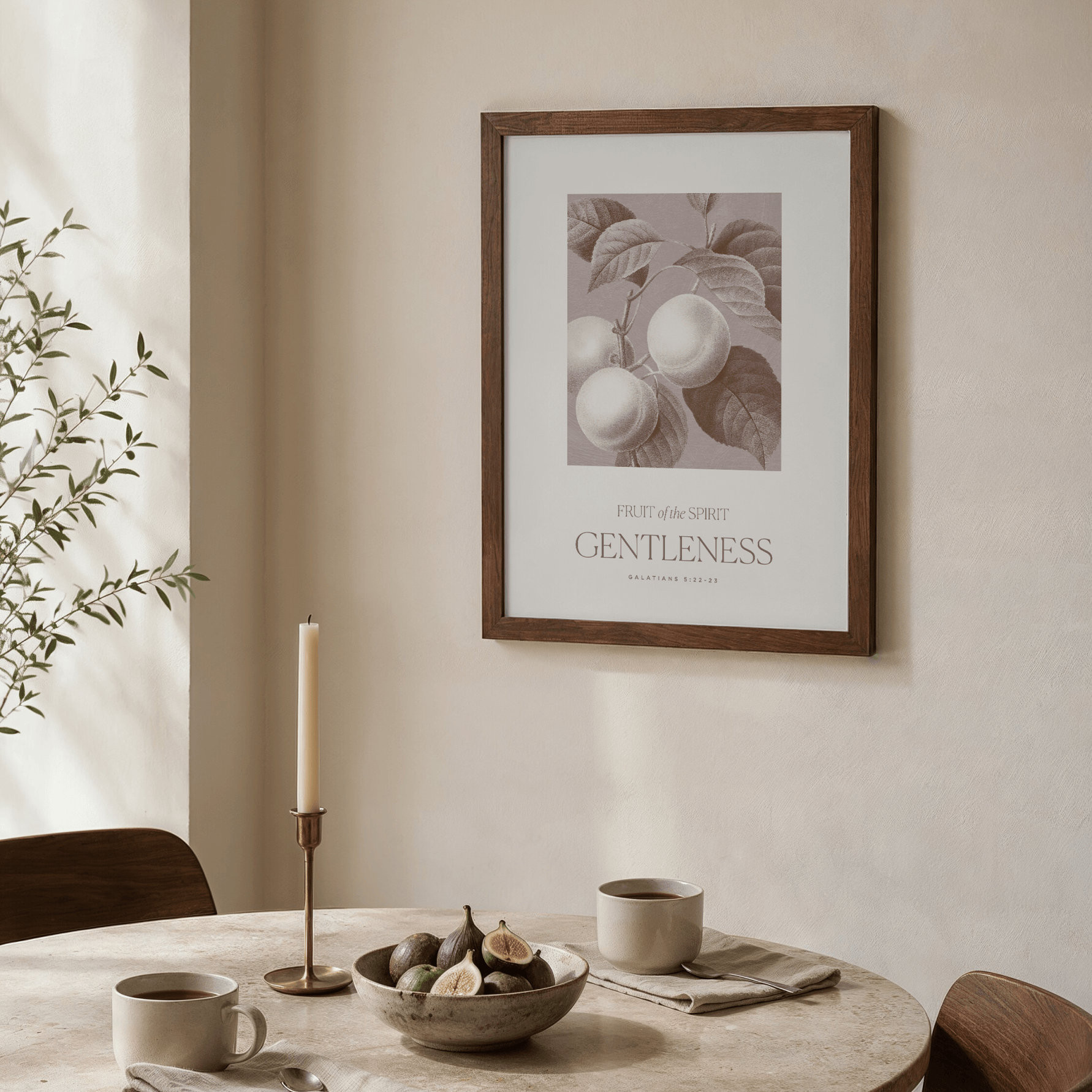 Framed artwork on a wall above a table with a candle and bowl.