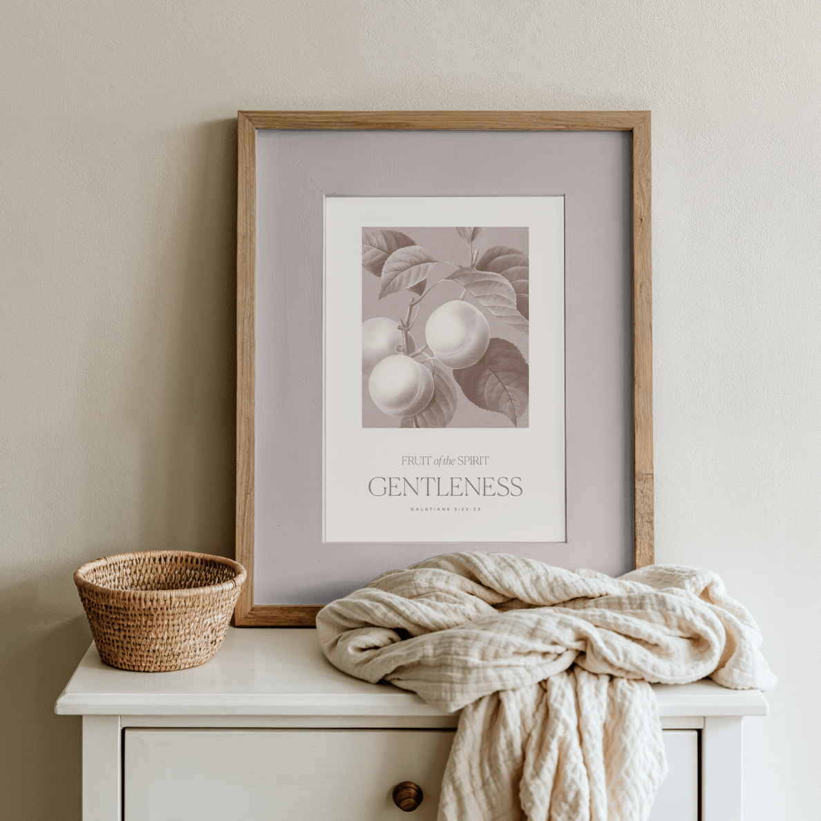 Framed artwork on a white surface with a basket and blanket
