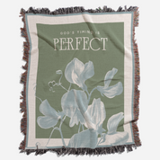 Blanket with floral design and 'God's Timing is Perfect' text on a green background
