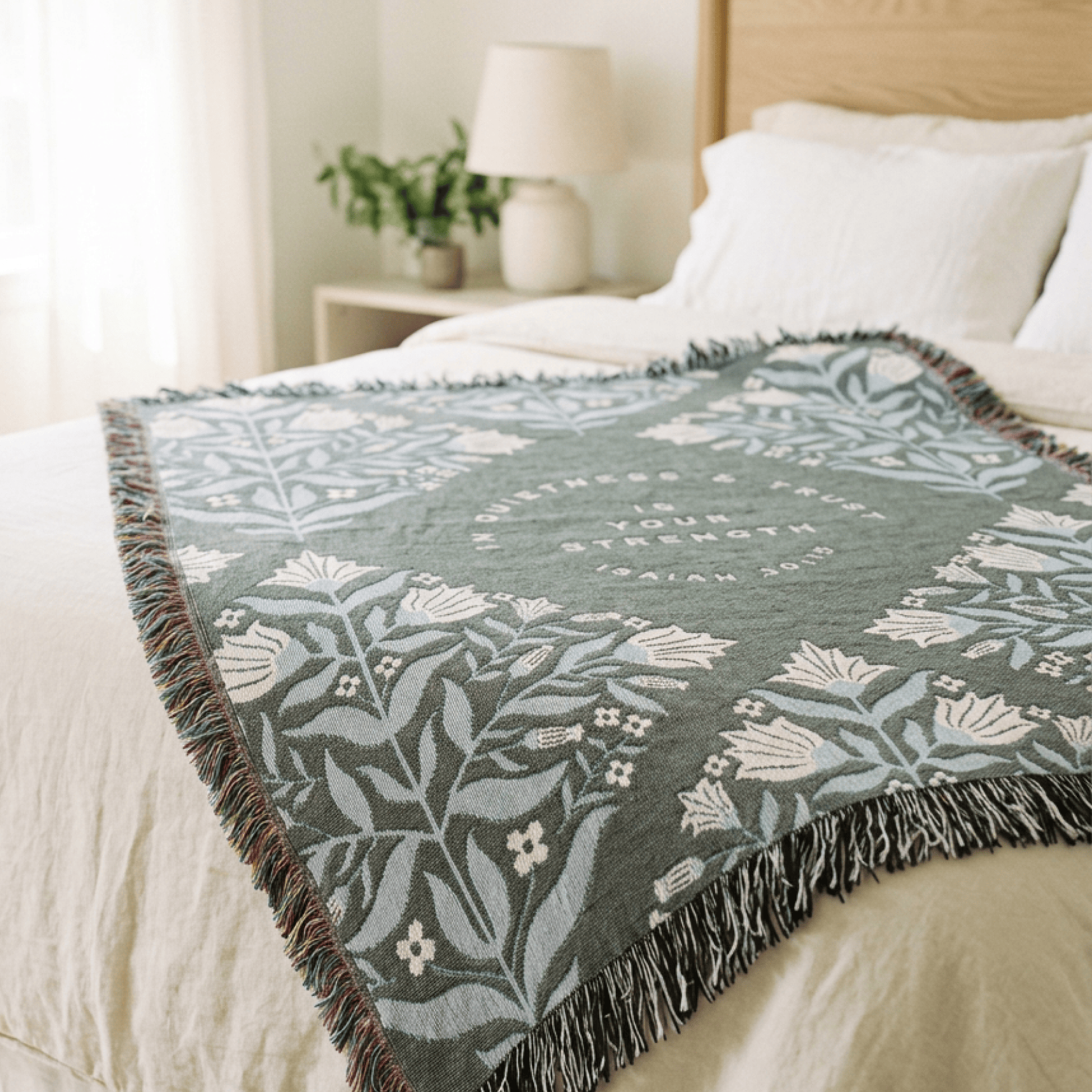 Isaiah 30:15 scripture blanket draped across bed in neutral bedroom setting