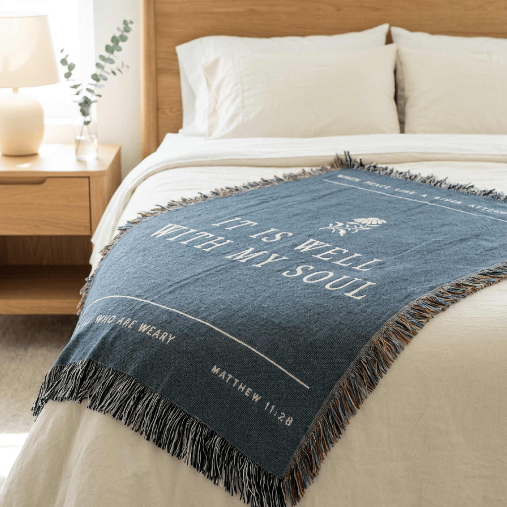 Blue throw blanket with text on a bed in a bedroom setting