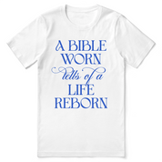 Christian t-shirt with the phrase “A Bible Worn Tells of a Life Reborn”; unisex cotton tee celebrating transformation through God's Word.