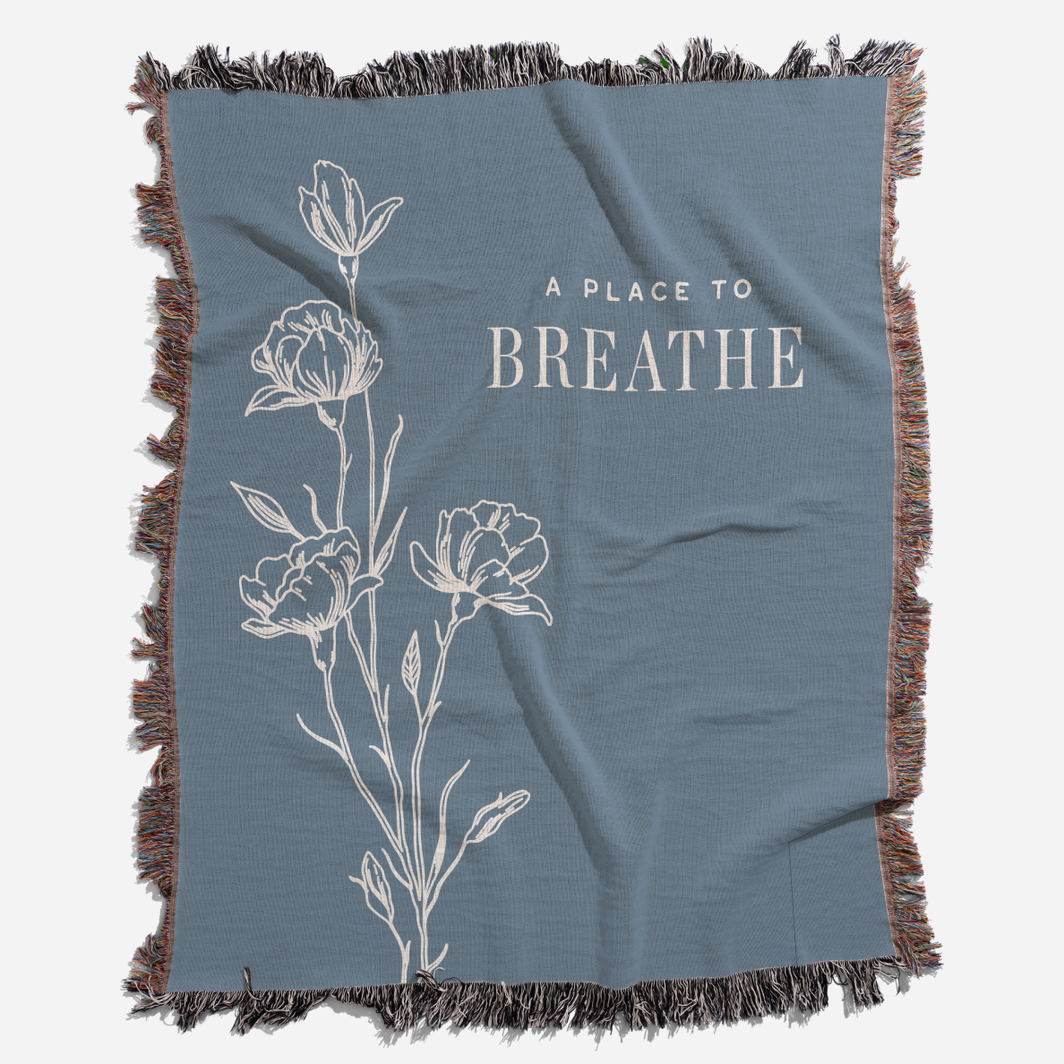Blue blanket with floral design and 'A Place to Breathe' text on a white background