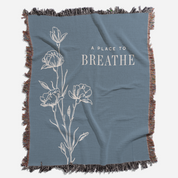 Blue blanket with floral design and 'A Place to Breathe' text on a white background