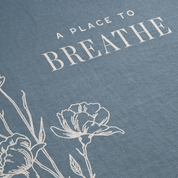 Text 'A Place to Breathe' with floral illustrations on a blue background