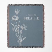 Blanket with floral design and 'A Place to Breathe' text on a blue background