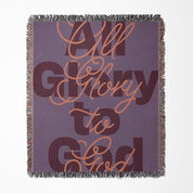 Blanket with 'All Glory to God' text on a purple background