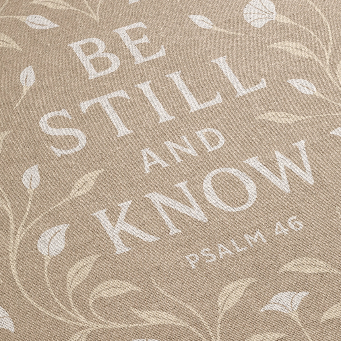 Cream-colored woven blanket with the phrase “Be still and know” from Psalm 46, made of 100% cotton with fringe; a peaceful Christian gift for nurseries or weddings.