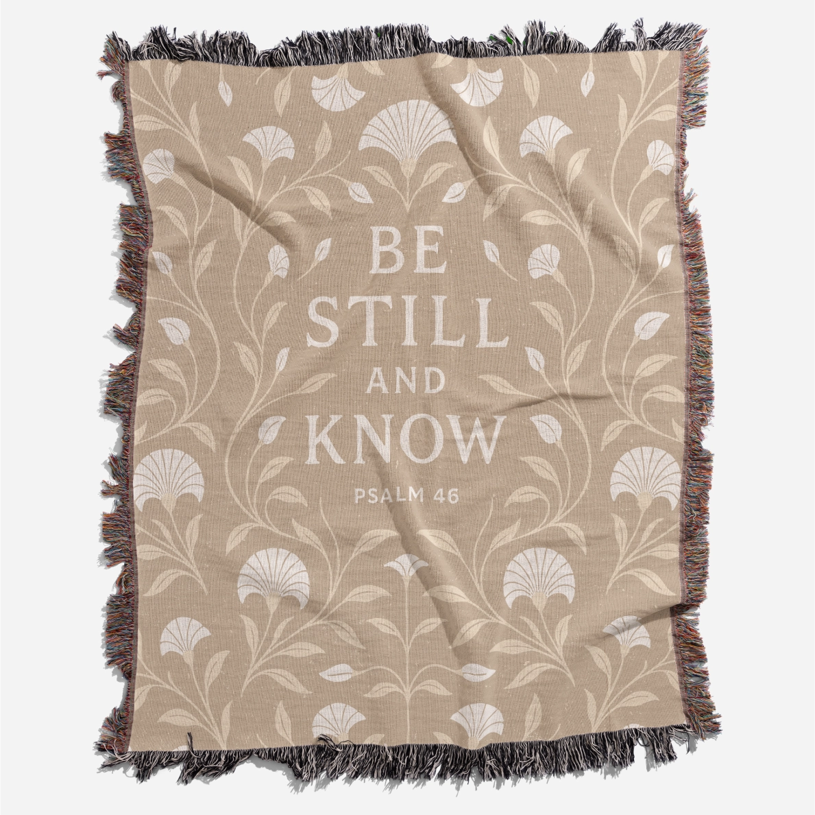 Cream-colored woven blanket with the phrase “Be still and know” from Psalm 46, made of 100% cotton with fringe; a peaceful Christian gift for nurseries or weddings.