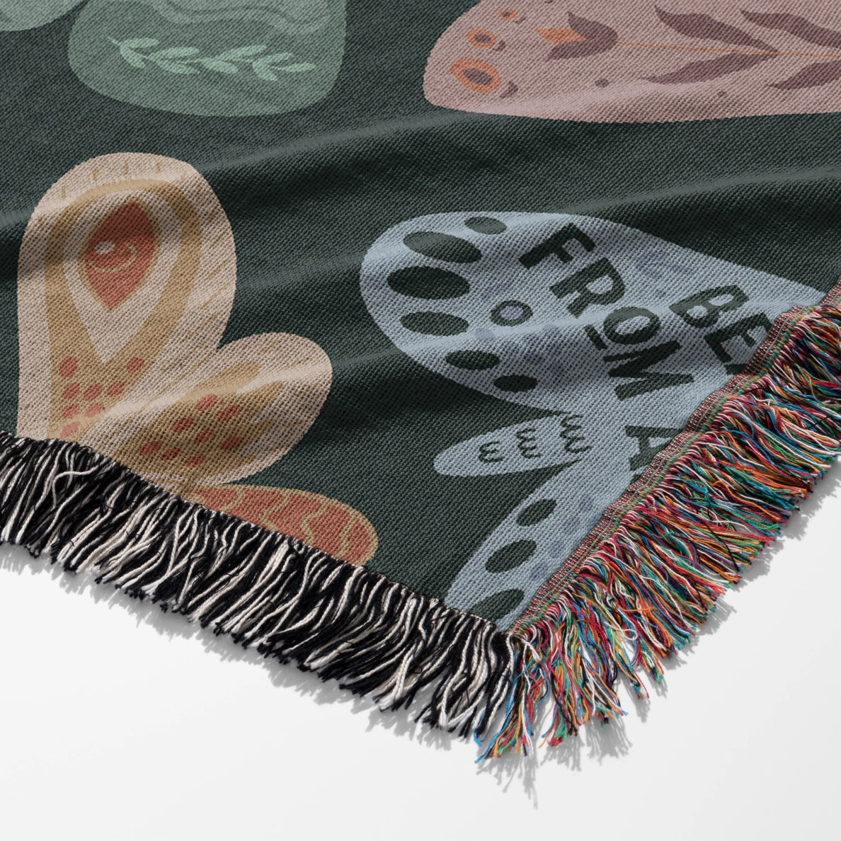 Faith-inspired woven blanket with hand-drawn butterflies and moths on a deep background, made from 100% cotton with colorful fringed edges—Christian home decor.