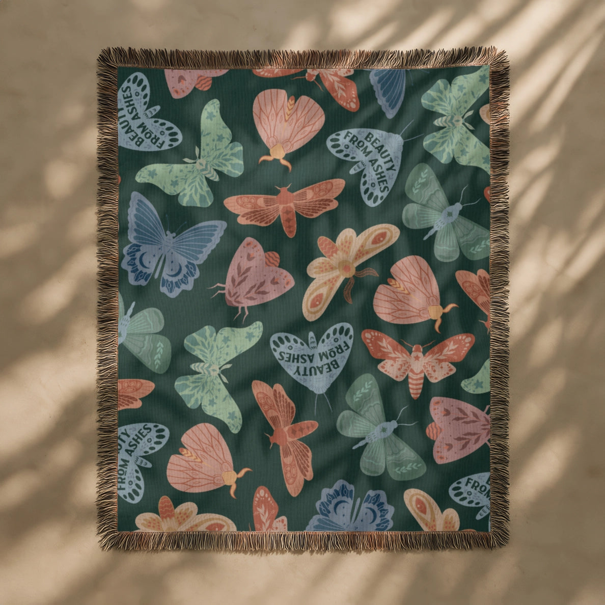 Faith-inspired woven blanket with hand-drawn butterflies and moths on a deep background, made from 100% cotton with colorful fringed edges—Christian home decor.