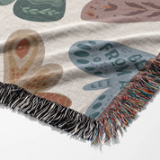 Faith-inspired woven blanket with hand-drawn butterflies and moths on a soft light background, made from 100% cotton with colorful fringed edges—Christian home decor.