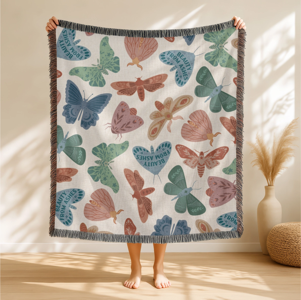 Faith-inspired woven blanket with hand-drawn butterflies and moths on a soft light background, made from 100% cotton with colorful fringed edges—Christian home decor.