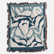 Floral patterned blanket with text 'Beauty in Every Season' on a white background