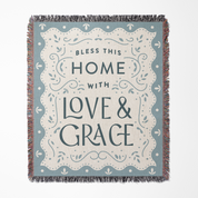 Blanket with 'Bless this home with love & grace' text on a blue background