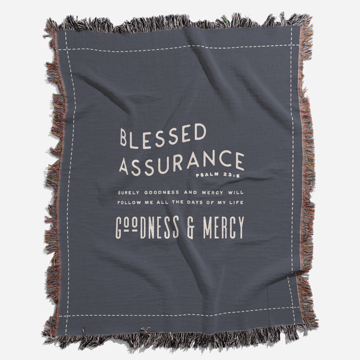 Gray blanket with text 'Blessed Assurance' and 'Goodness & Mercy' on a white background