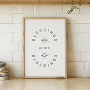 Framed artwork with 'Blessings Upon Blessings' text on a tiled wall.
