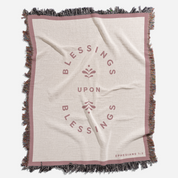 Blanket with 'Blessings Upon Blessings' text and fringes on a white background