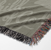 Green earthy-toned woven blanket with foliage pattern and “Child of God” text; made of 100% cotton with fringe, ideal for nurseries, kids’ rooms, or Christian gifts.