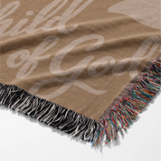 Woven cotton blanket with “Child of God” text and sunset-colored foliage design, finished with fringe; perfect for Christian nursery, baby gift, or faith-based home décor.