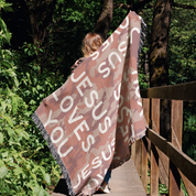 Woman holding blanket on bridge.