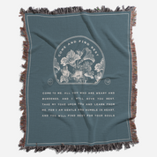 Teal blanket with floral design and text on a white background